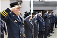 Side view of uniformed individuals saluting