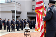 Man in uniform holding the American flag with uniformed individuals in background