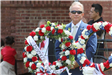 Man standing behind floral wreaths
