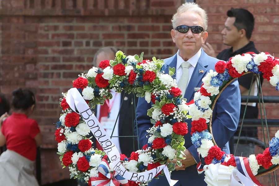 Man standing behind floral wreaths
